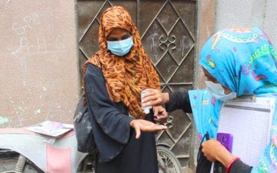 Vaccinator w/ sanitizer as Covid precaution in Pakistan