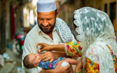 Father with child receiving Oral Polio Vaccination in Pakistan